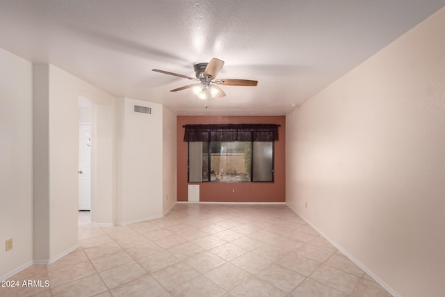 unfurnished room with ceiling fan and a textured ceiling