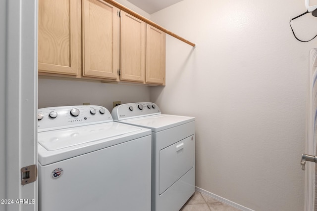 laundry area with cabinets, light tile patterned flooring, and washer and clothes dryer