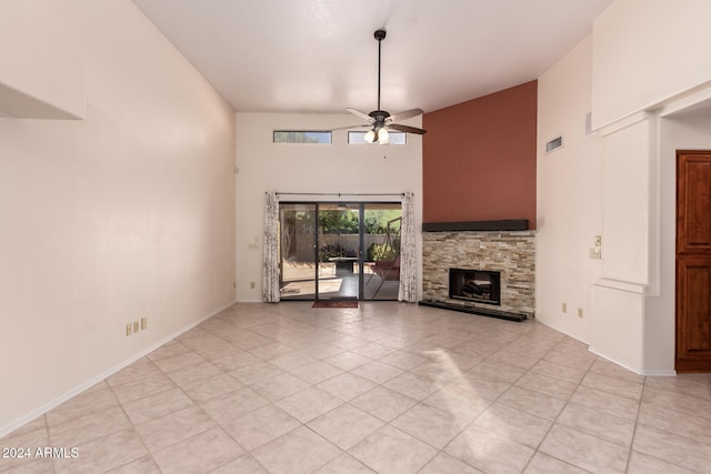 unfurnished living room with a stone fireplace, high vaulted ceiling, light tile patterned floors, and ceiling fan