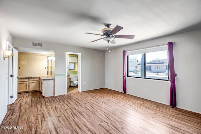 unfurnished bedroom with visible vents, a ceiling fan, light wood-style flooring, and ensuite bathroom