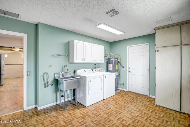 laundry room with washer and dryer, cabinet space, visible vents, and electric water heater