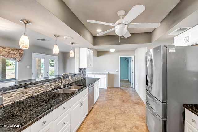 kitchen featuring visible vents, a sink, tasteful backsplash, stainless steel appliances, and white cabinets