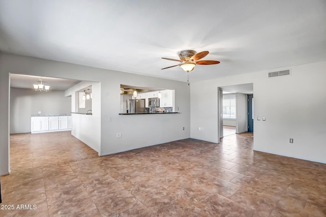 spare room with ceiling fan with notable chandelier and visible vents