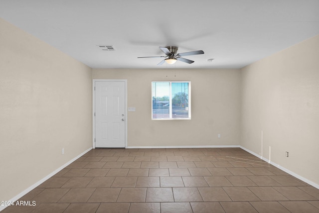 tiled spare room with ceiling fan