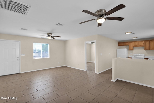 unfurnished living room featuring tile patterned flooring and ceiling fan