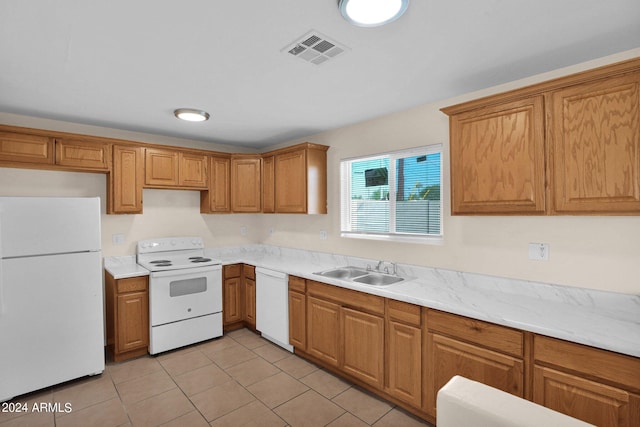 kitchen with light stone counters, white appliances, sink, and light tile patterned floors