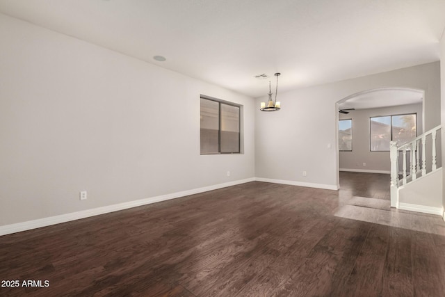 unfurnished room with dark wood-type flooring and a chandelier