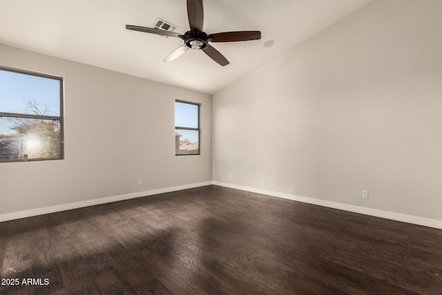 empty room featuring vaulted ceiling, dark hardwood / wood-style floors, and ceiling fan