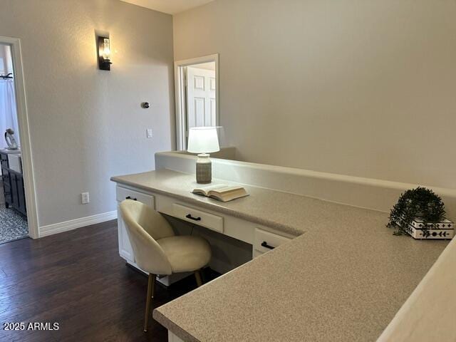 unfurnished office with baseboards and dark wood-style floors