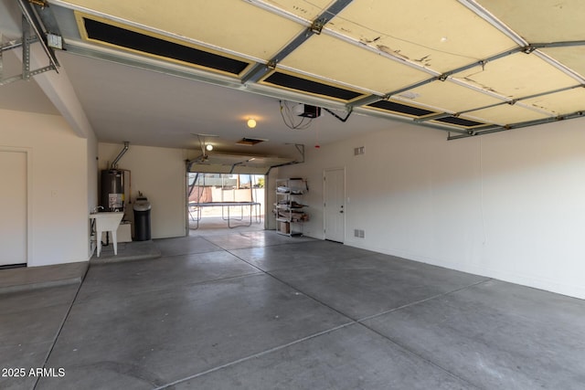 garage featuring a trampoline, a garage door opener, and water heater