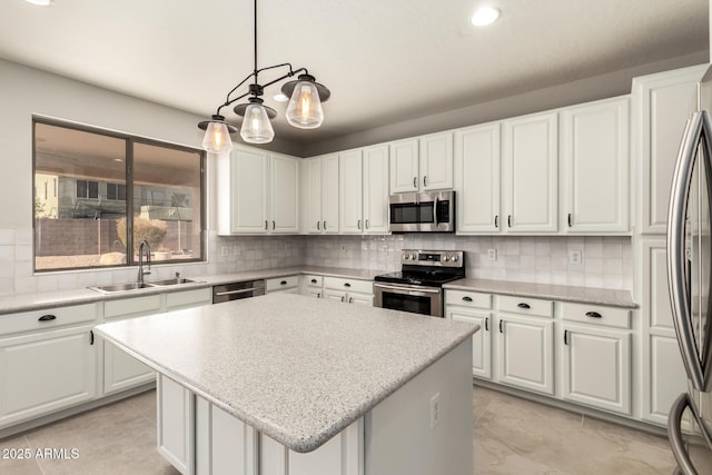 kitchen with pendant lighting, white cabinetry, sink, a center island, and stainless steel appliances