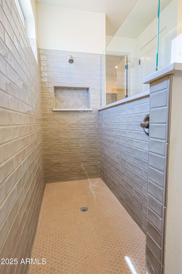 bathroom with tile patterned flooring and tiled shower