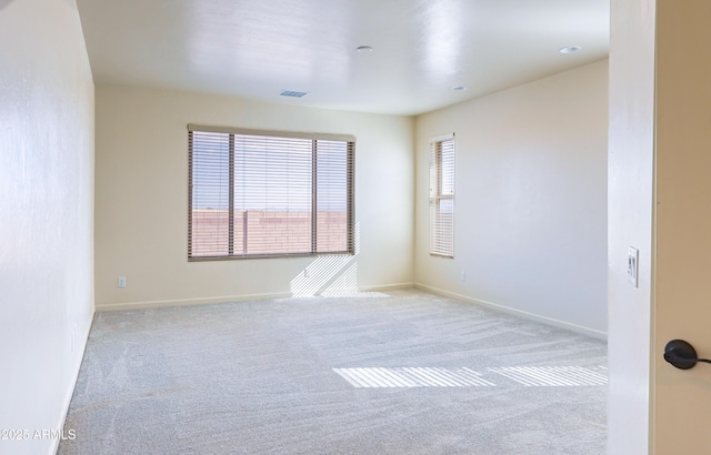 unfurnished room with baseboards, carpet flooring, and visible vents