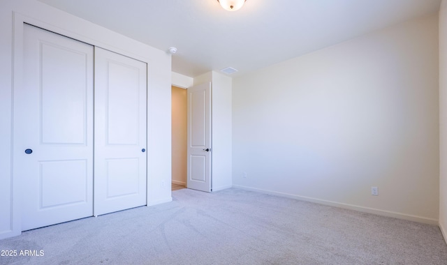 unfurnished bedroom with carpet floors, baseboards, and a closet