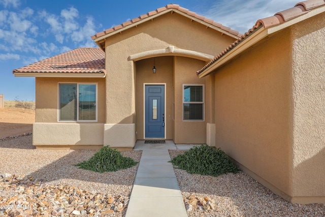 property entrance featuring stucco siding and a tiled roof