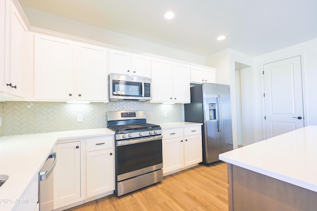 kitchen featuring light wood-style floors, light countertops, white cabinetry, tasteful backsplash, and appliances with stainless steel finishes