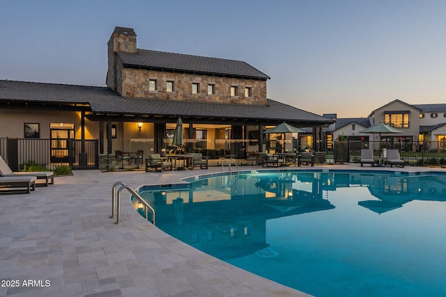 pool at dusk with a patio