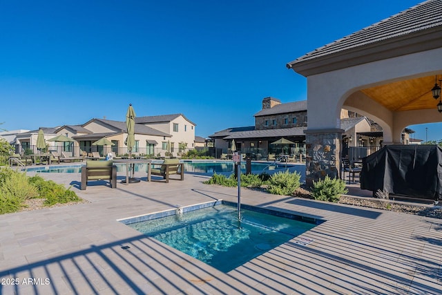 view of swimming pool featuring a patio and a community hot tub