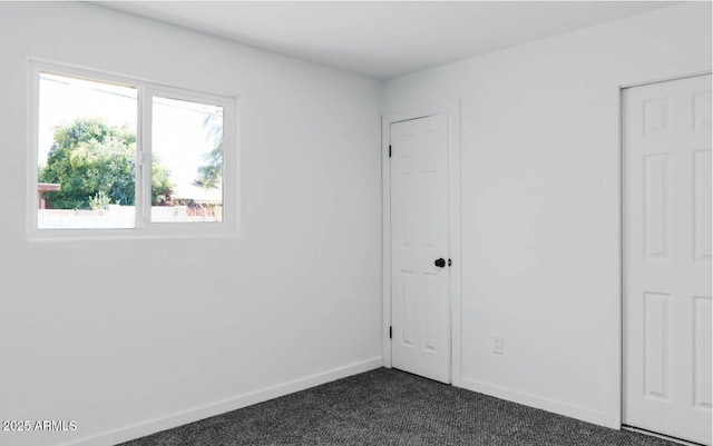 unfurnished bedroom featuring dark carpet