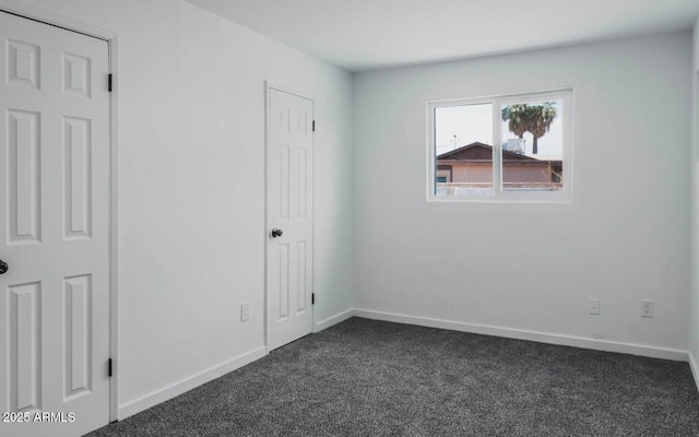 spare room featuring dark carpet