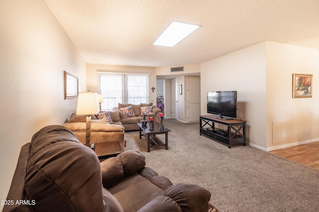 living room featuring carpet and a textured ceiling