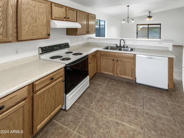 kitchen with white appliances, ceiling fan with notable chandelier, sink, decorative light fixtures, and kitchen peninsula