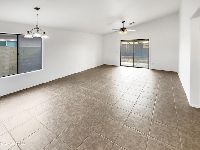 tiled empty room featuring ceiling fan with notable chandelier and vaulted ceiling