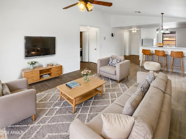 tiled living room with ceiling fan with notable chandelier and vaulted ceiling