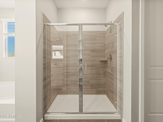 bathroom featuring a shower stall and a bath