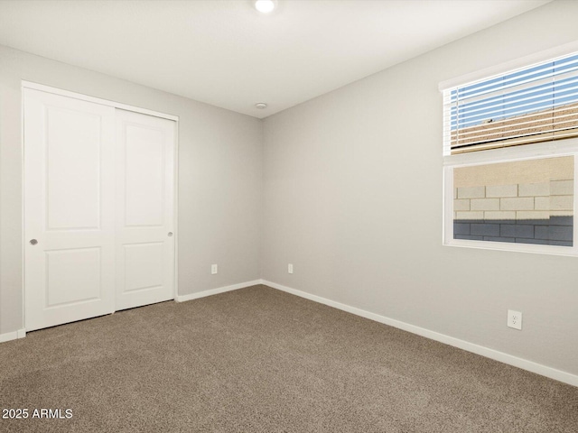 unfurnished bedroom with carpet floors, baseboards, and a closet