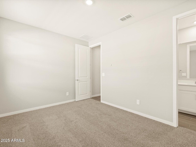 empty room with baseboards, visible vents, and carpet flooring