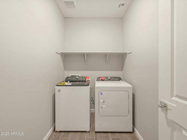 laundry room featuring laundry area, visible vents, baseboards, and washing machine and clothes dryer