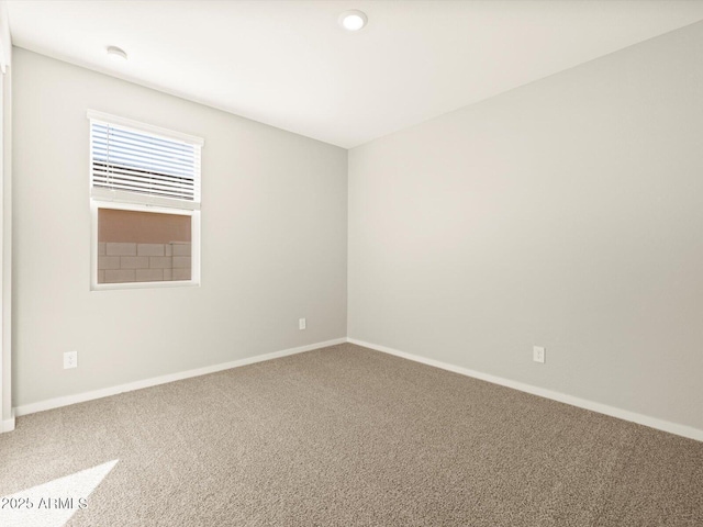 unfurnished room with carpet floors and baseboards