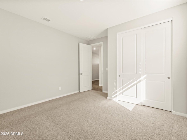 unfurnished bedroom with a closet, baseboards, visible vents, and carpet flooring