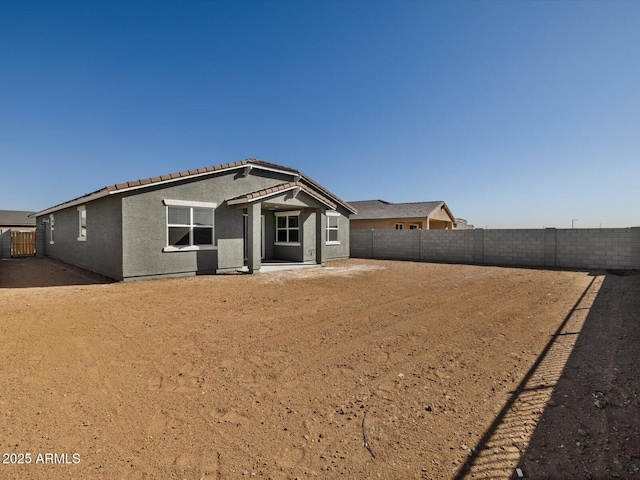 single story home featuring a fenced backyard, a patio, a tiled roof, and stucco siding