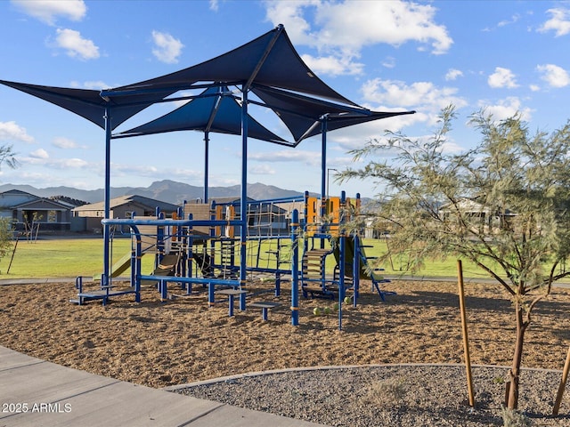 community playground with a mountain view and a yard