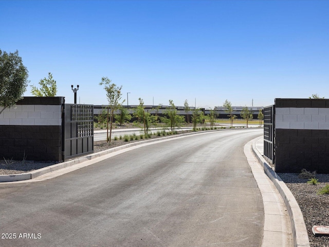 view of street featuring curbs and a gate