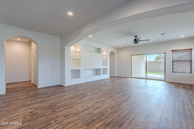 unfurnished living room featuring dark hardwood / wood-style floors, built in features, and ceiling fan