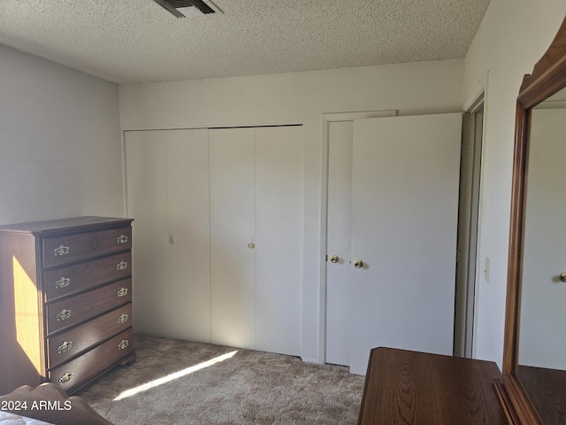 unfurnished bedroom with multiple closets, dark carpet, and a textured ceiling