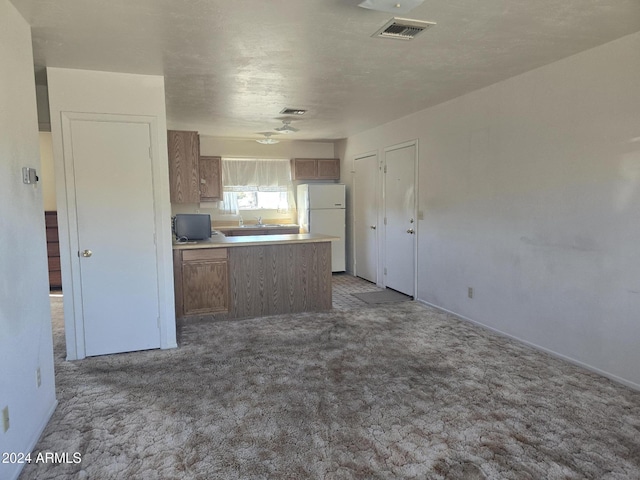 kitchen featuring white fridge and light carpet