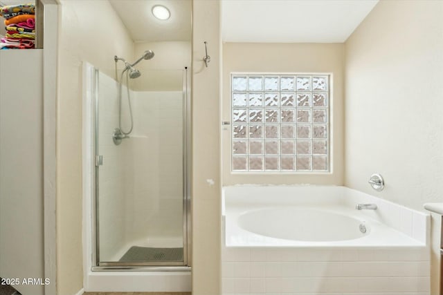 full bathroom with a stall shower and a garden tub