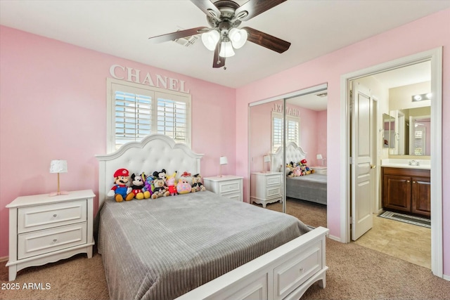 bedroom with light carpet, a closet, connected bathroom, a ceiling fan, and a sink