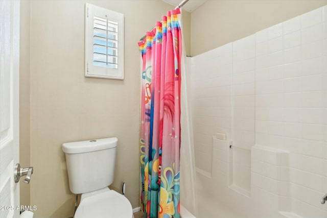 bathroom featuring toilet and shower / tub combo with curtain