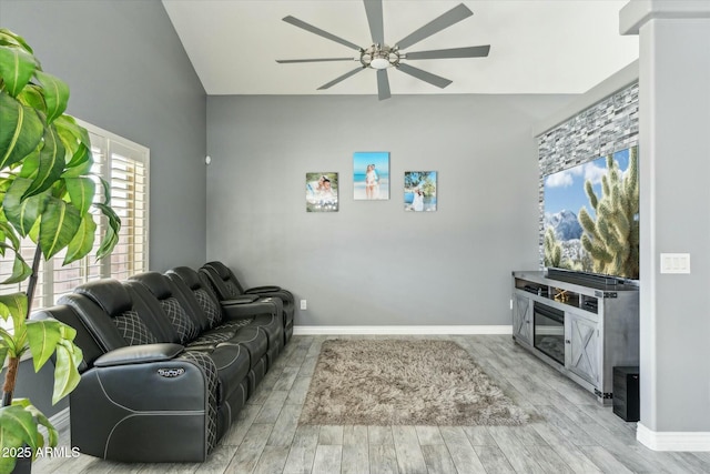 living area with light wood finished floors, baseboards, and a ceiling fan