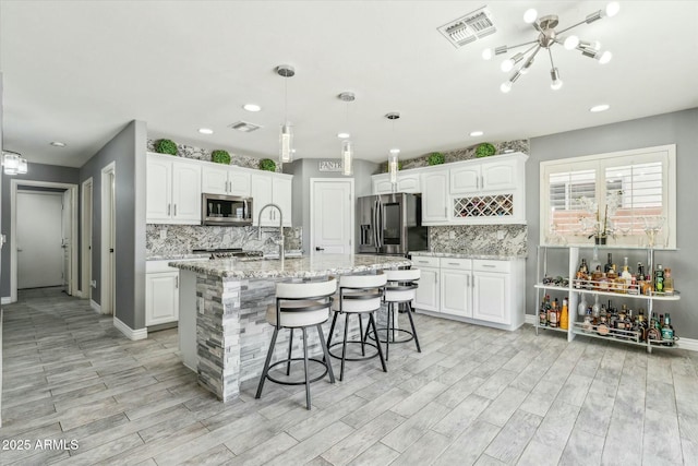 kitchen featuring white cabinetry, visible vents, appliances with stainless steel finishes, and a sink