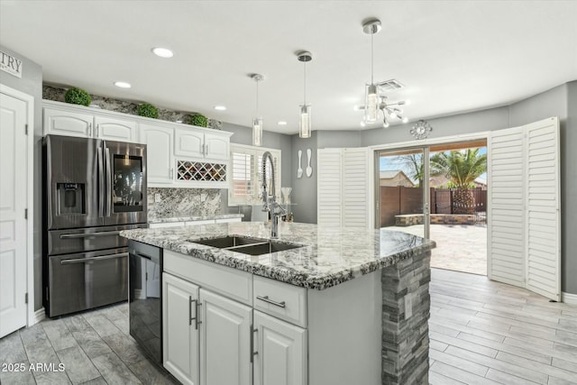 kitchen with black dishwasher, stainless steel refrigerator with ice dispenser, visible vents, white cabinetry, and a sink