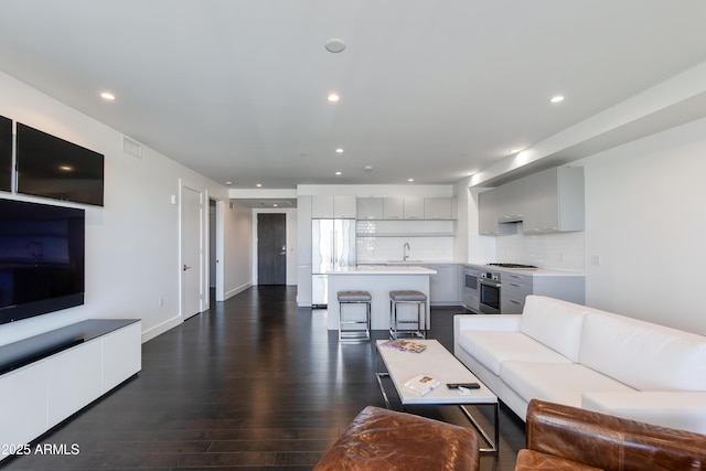 living room with dark hardwood / wood-style flooring and sink