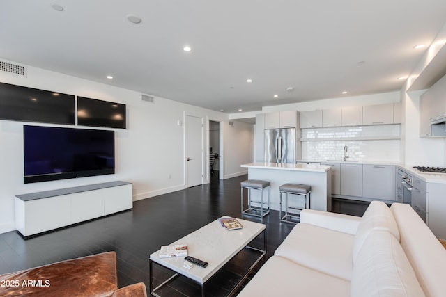 living room with sink and dark wood-type flooring