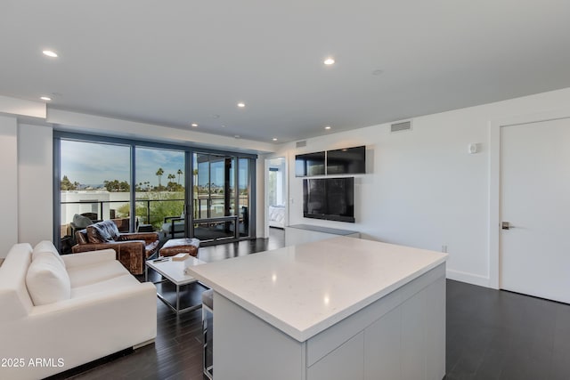 kitchen with dark hardwood / wood-style floors, a center island, and white cabinets