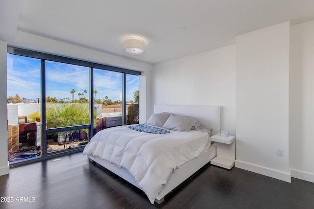 bedroom featuring access to outside and dark hardwood / wood-style flooring